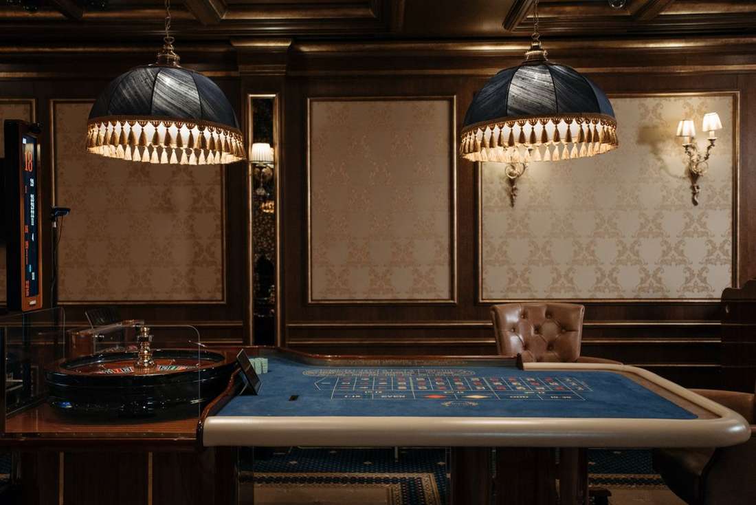 Interior kasino dengan lampu gemerlap sebagai ilustrasi tema permainan daring